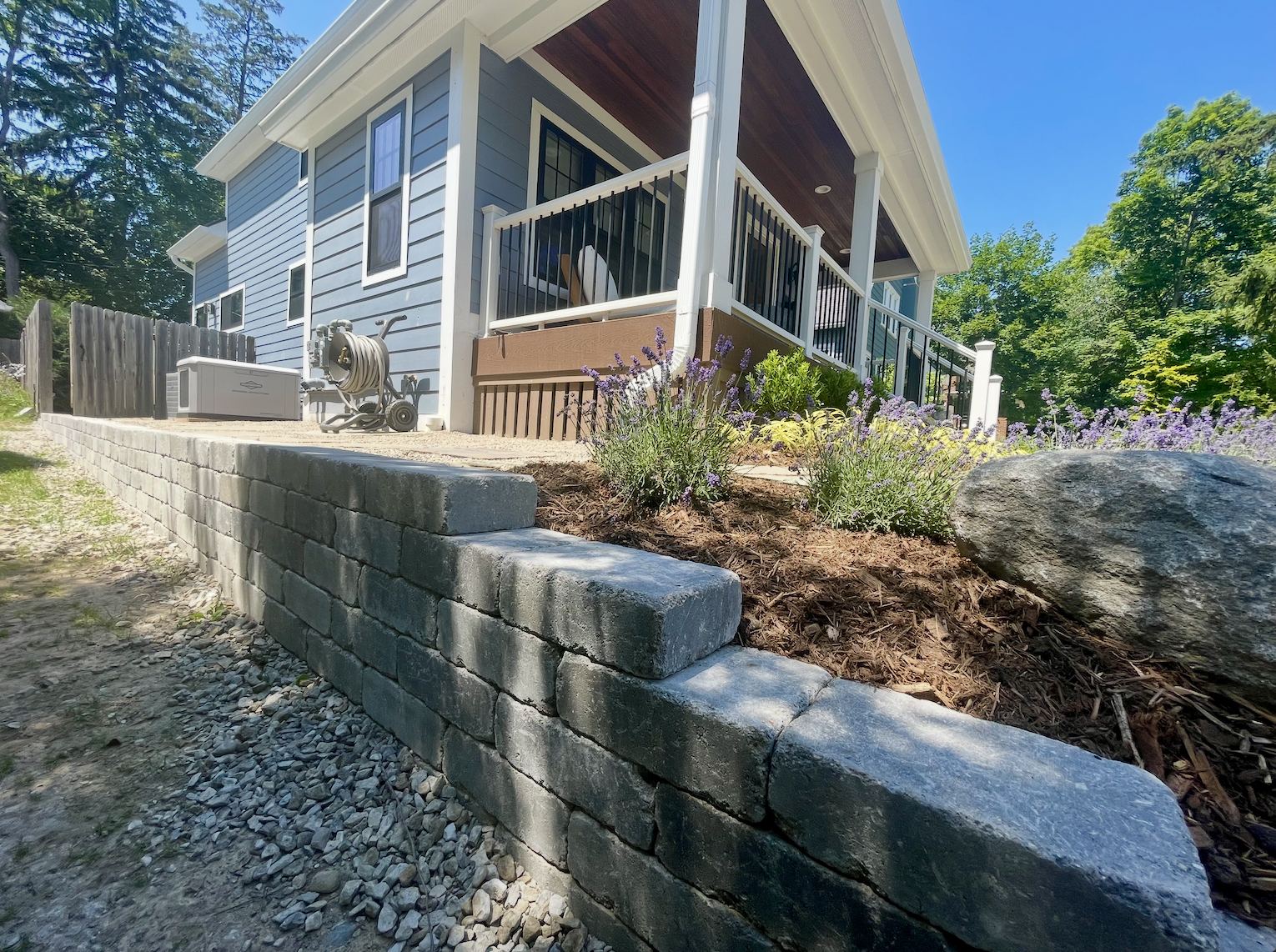 Charcoal block retaining wall with lavender and perennial planting beside a covered porch, Ann Arbor