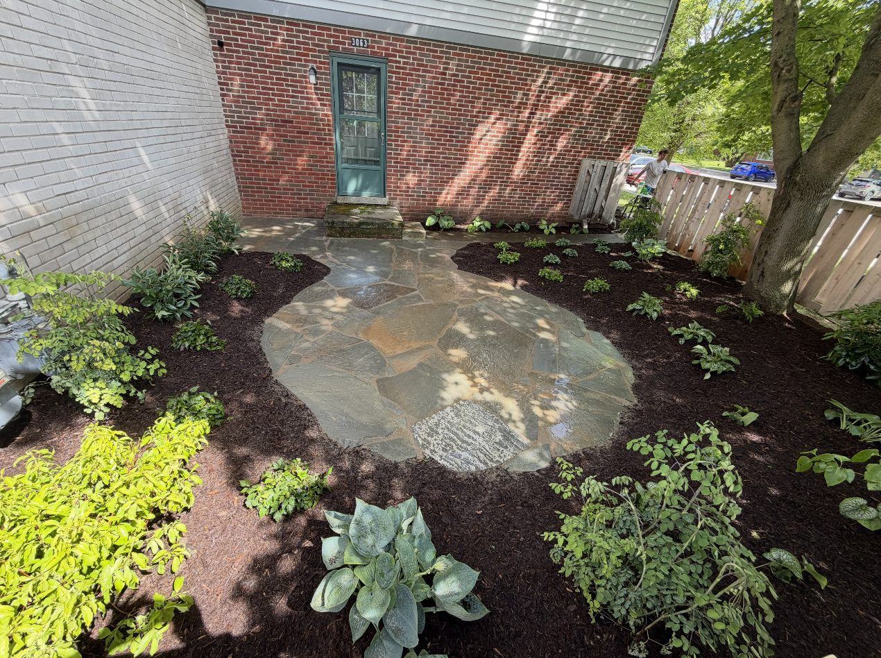 Flagstone courtyard patio with fresh plantings by the front entry
