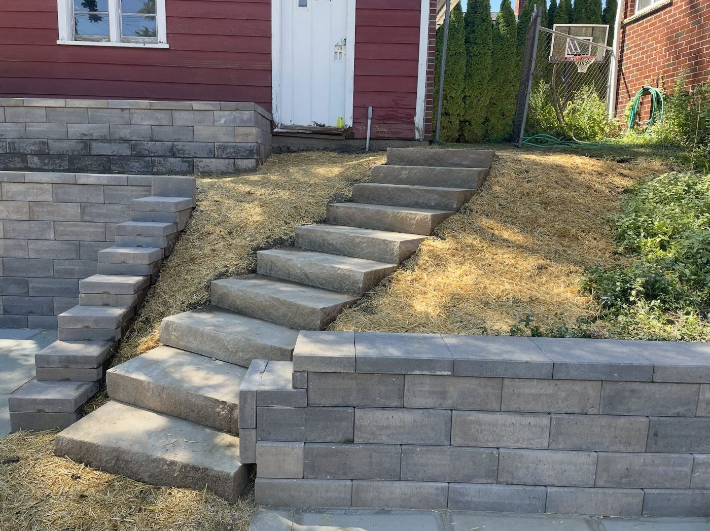 Natural chunk stone steps climbing a hillside between new retaining walls