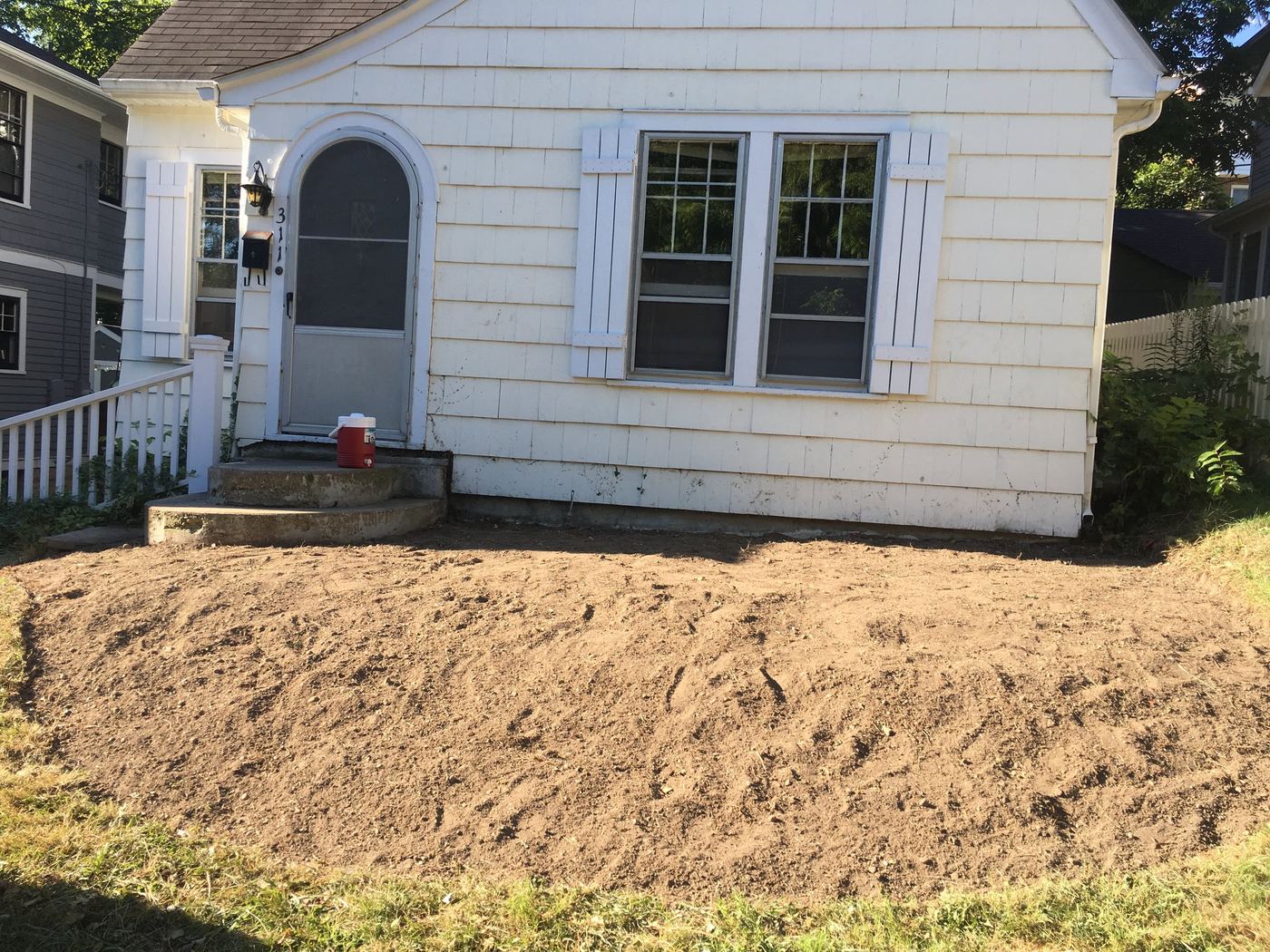 Bare dirt bed before cottage garden installation
