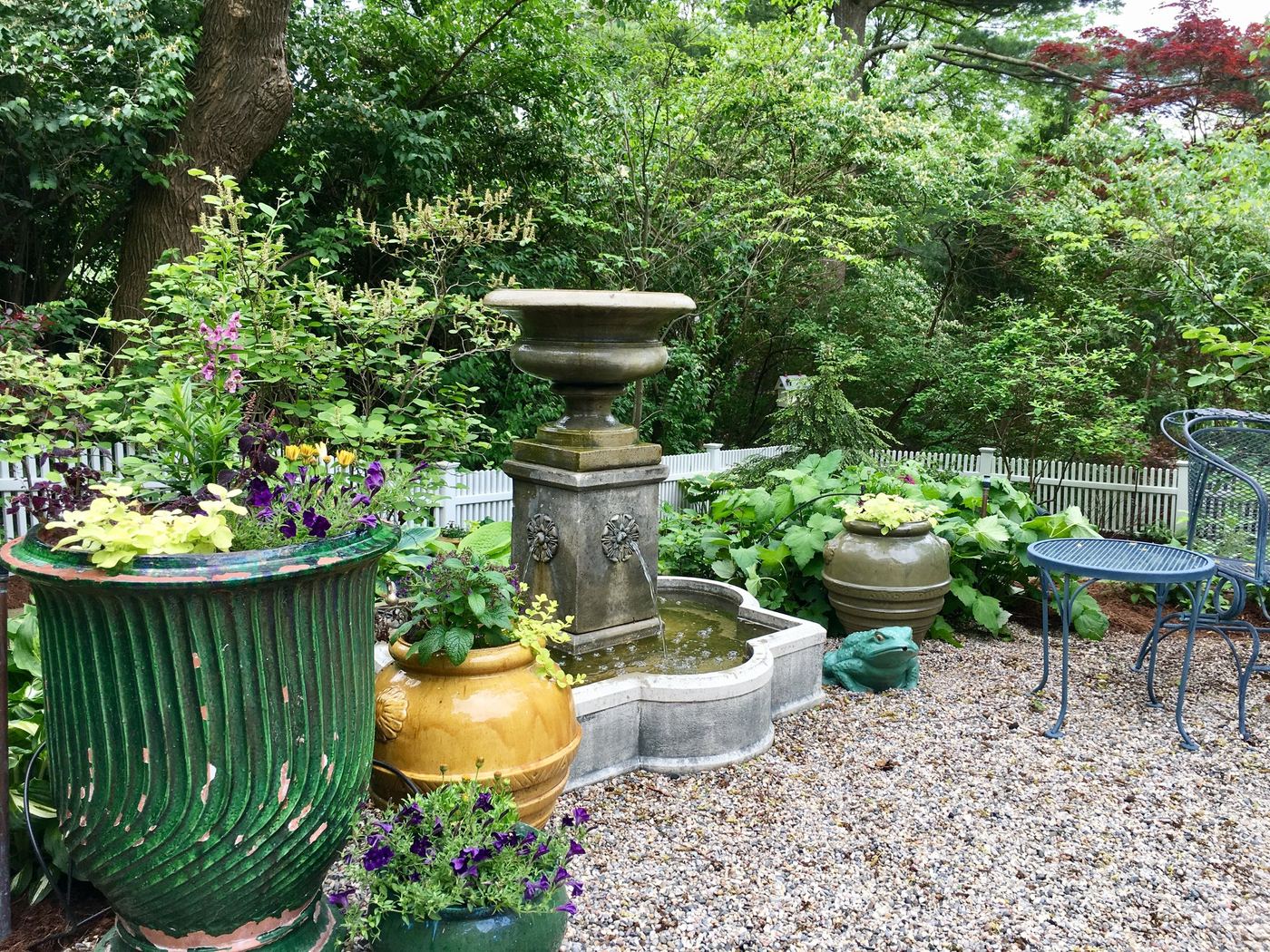Garden urns and stone fountain detail in a maintained bed