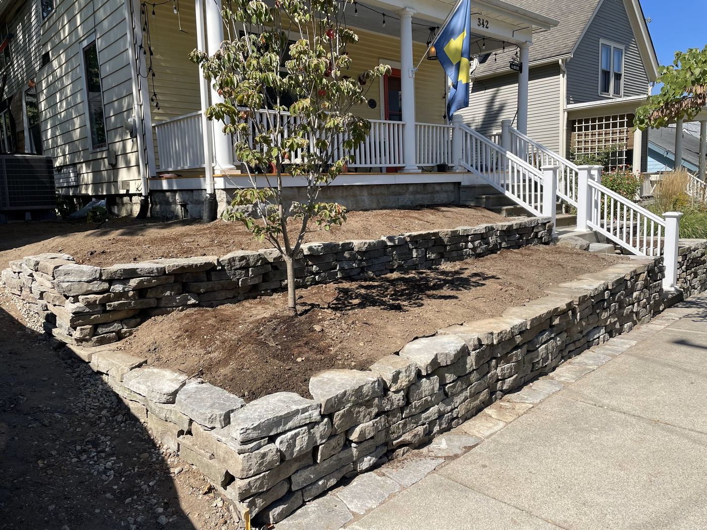 Stacked stone wall framing a new garden bed