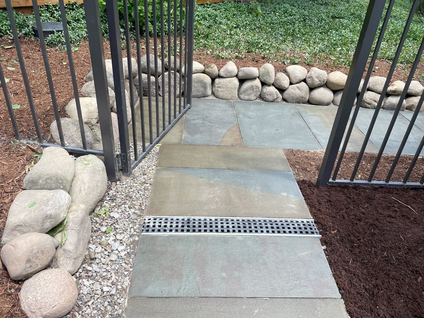 Boulder rock wall and bluestone walkway