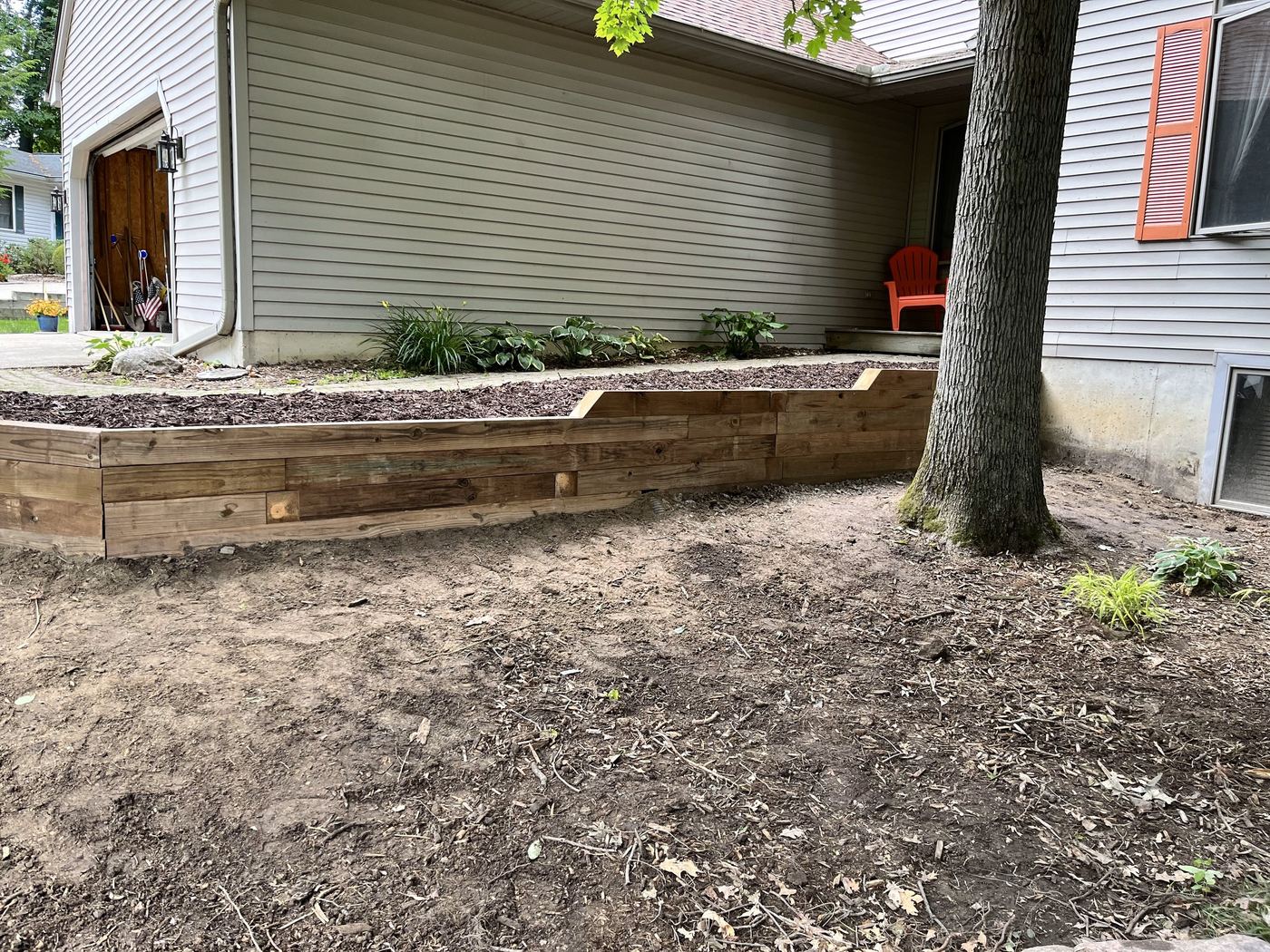 Finished tiered wood retaining wall with mulched bed